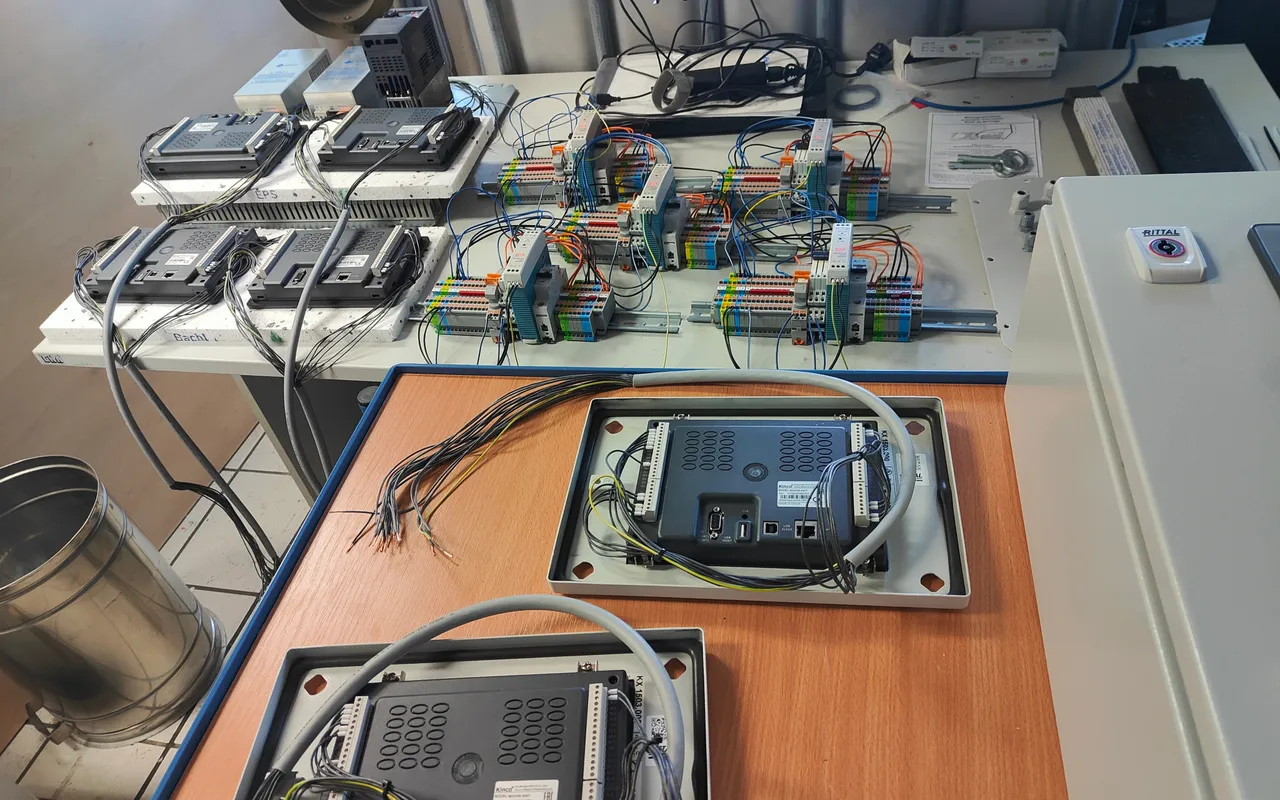 Operator panels wired on a build bench, cable looms laid out beside them