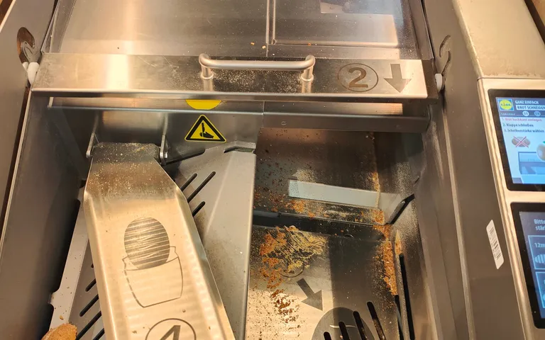 Interior of a food machine with the guard open and product residue on the bed