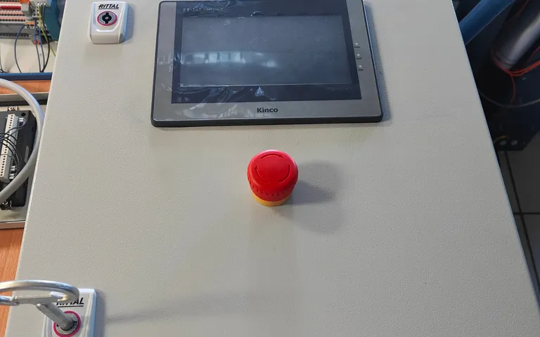Operator interface on a cabinet door beside a red emergency stop