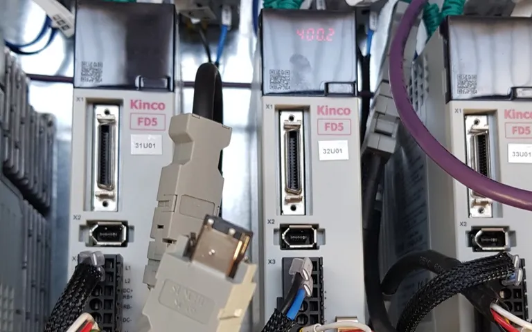 Two servo drives mounted side by side in a cabinet with motor and encoder cables landed