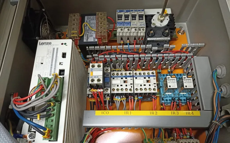 Open cabinet with a drive, contactors and control wiring on the backplate