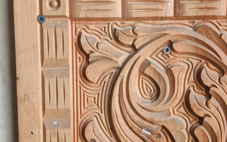 Ornate relief pattern machined into a wooden panel