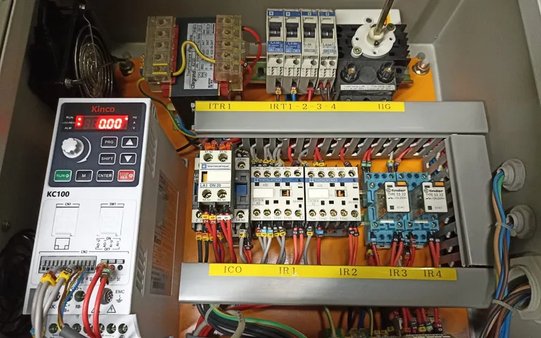 Drive, contactors and terminal rails on a cabinet backplate with wiring dressed to ducts