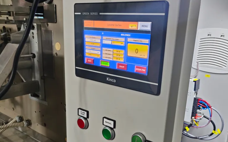Operator interface on a packaging machine with emergency stop and selector switches beneath it