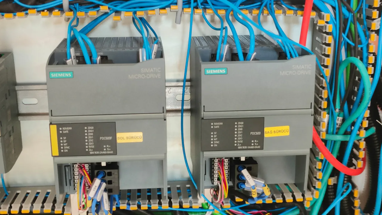 Two installed PLCs wired into a machine cabinet, terminal rails and cable ducts either side