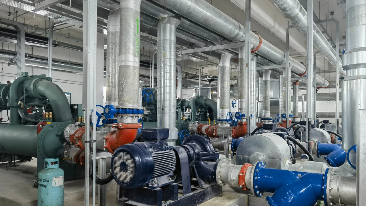 Pump sets, isolation valves and headers lined up along a plant-room wall