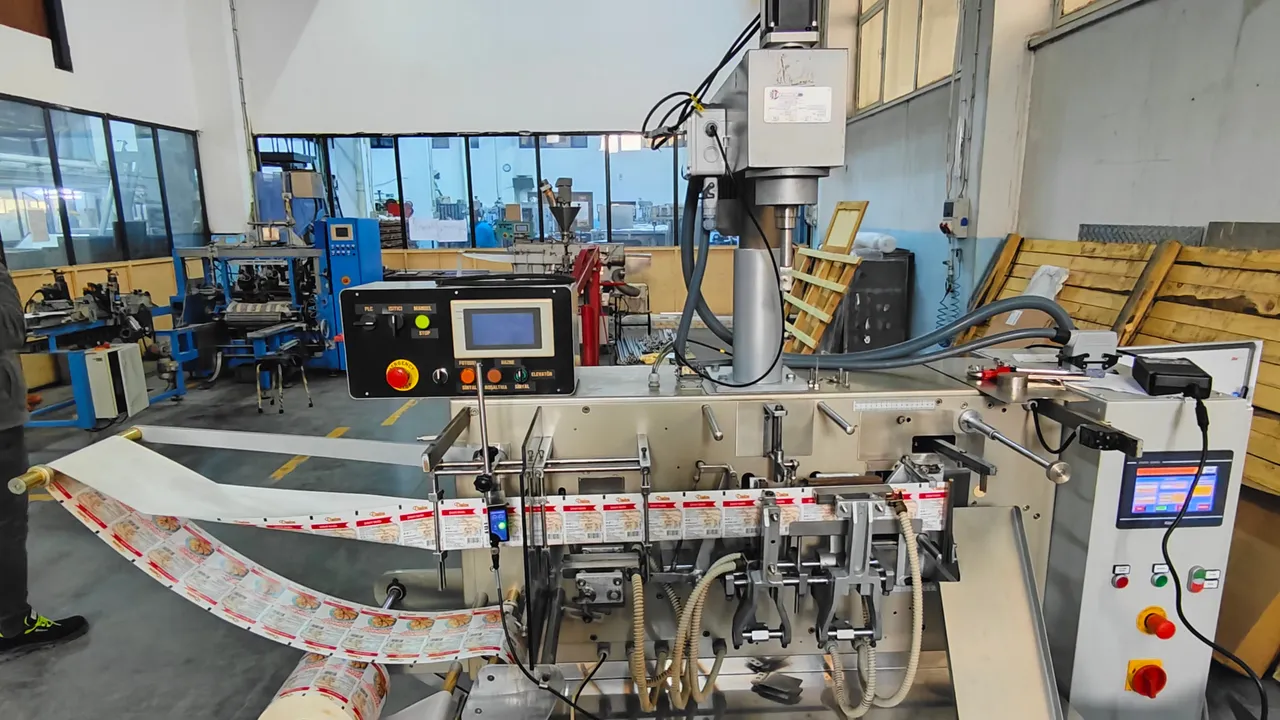 Vertical form-fill-seal machine running film, with a panel-mounted operator interface