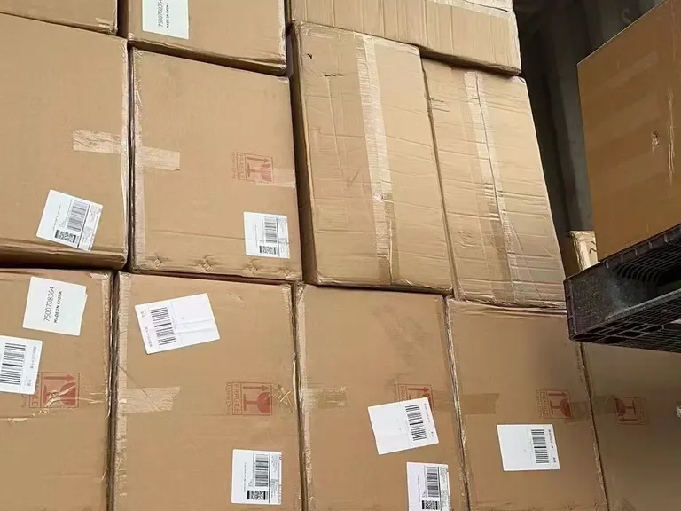 Cartons stacked in a shipping container with barcode labels and printed carton markings